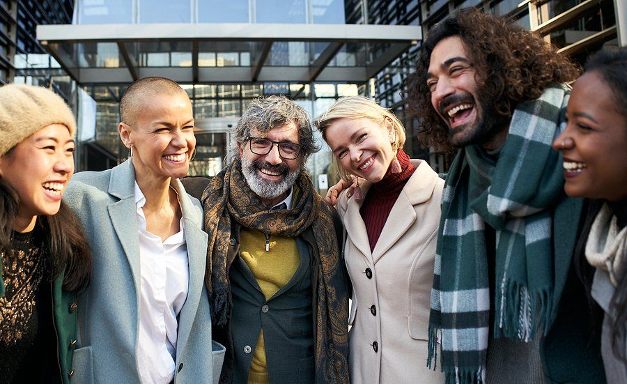 Happy employees/professionals smile while hanging out outside/at the office