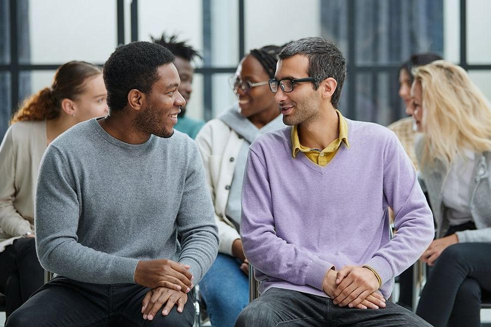 Happy employees talk to each other at work