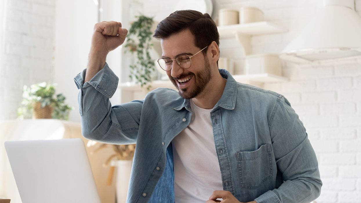 Happy/excited man on laptop finds out he got the job he interviewed for