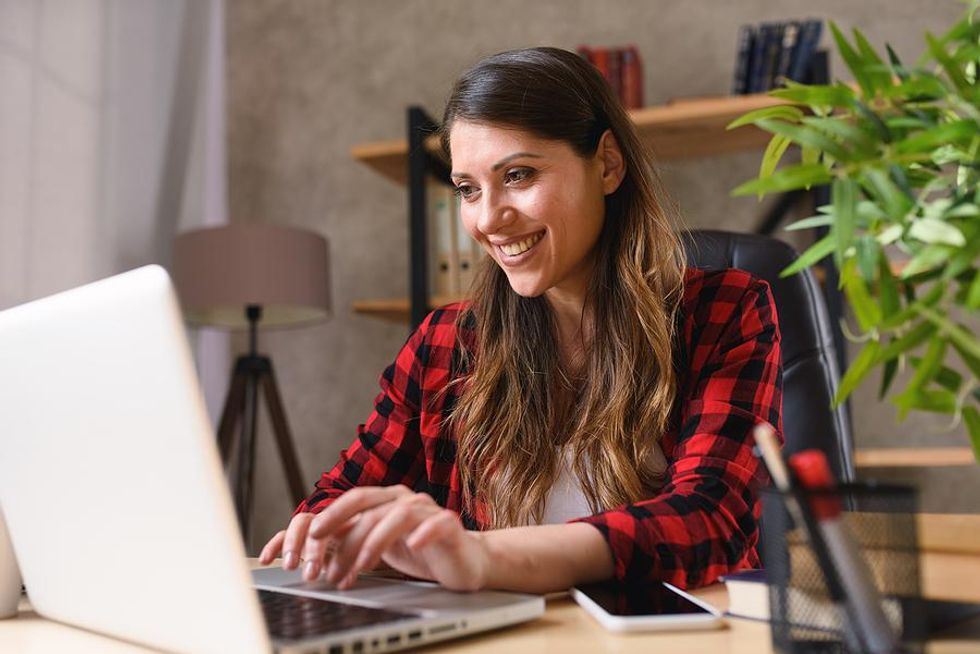 Happy hybrid employee working at her desk
