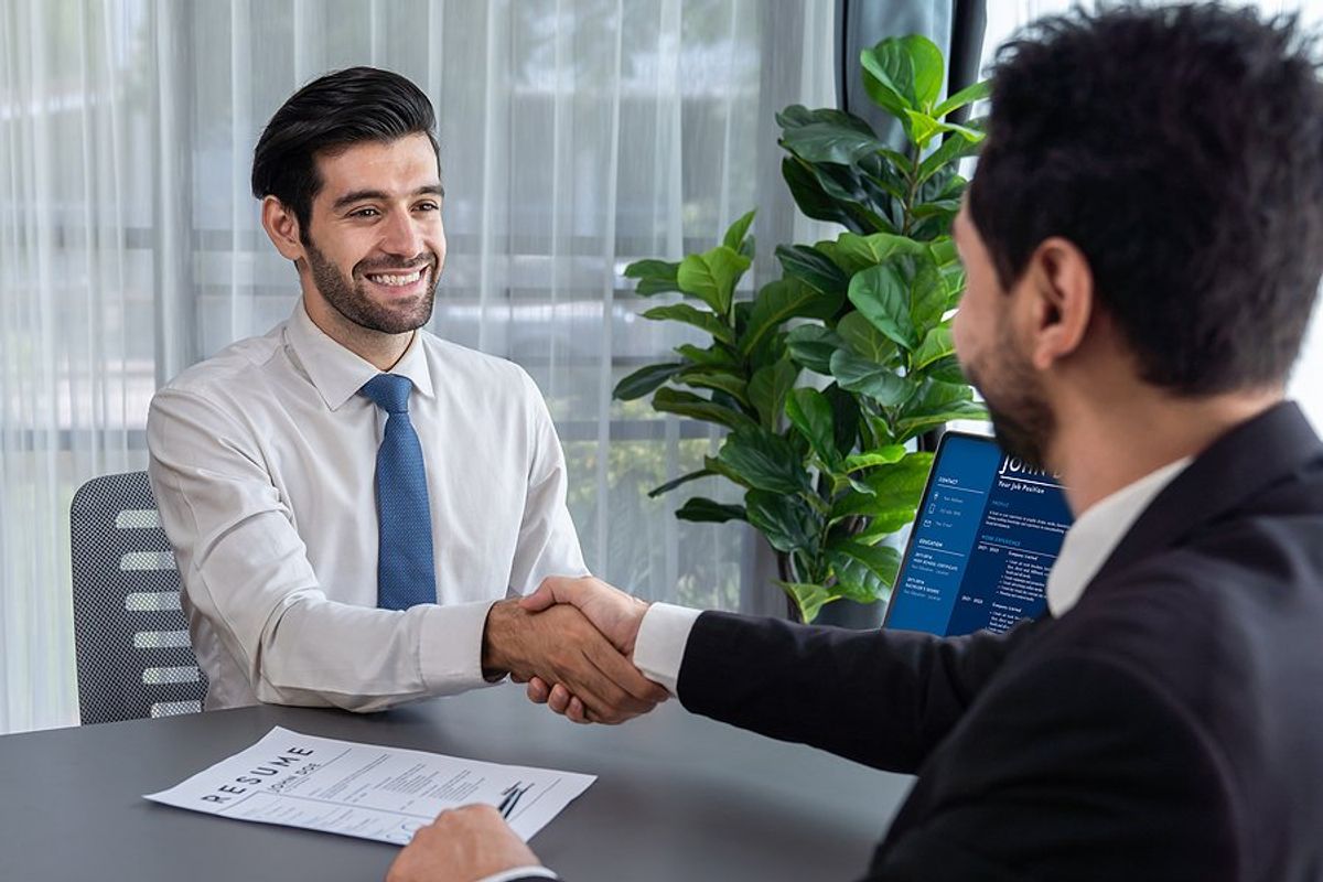 Happy job candidate shakes hands with the recruiter/hiring manager before an interview