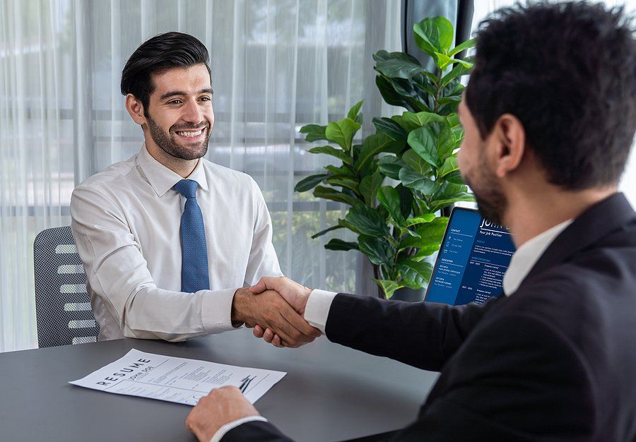 Happy job candidate shakes hands with the recruiter/hiring manager before an interview