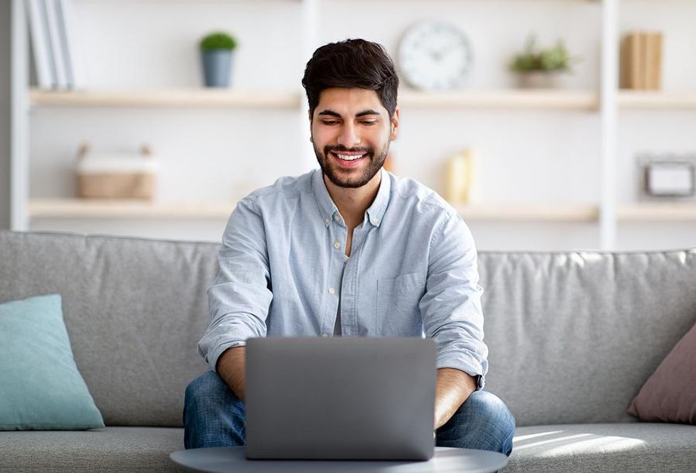 Happy man on laptop sends a LinkedIn invitation
