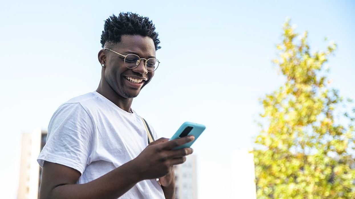 Happy man on phone talks to his career coach at Work It DAILY
