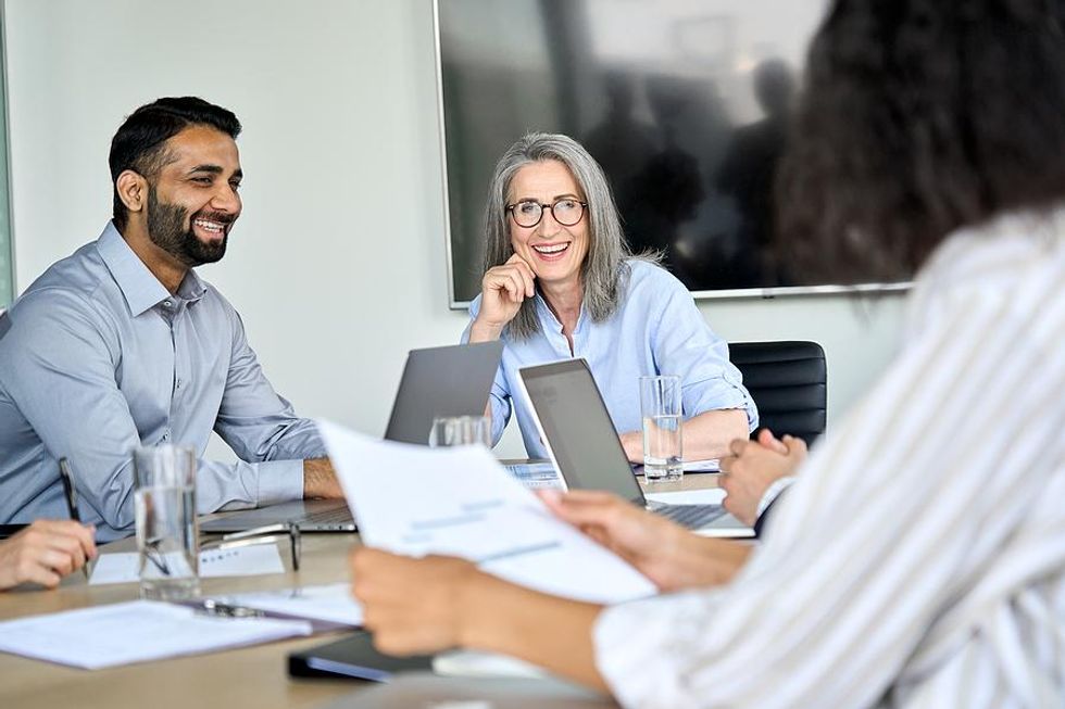 Happy manager talks with her colleagues during a work meeting