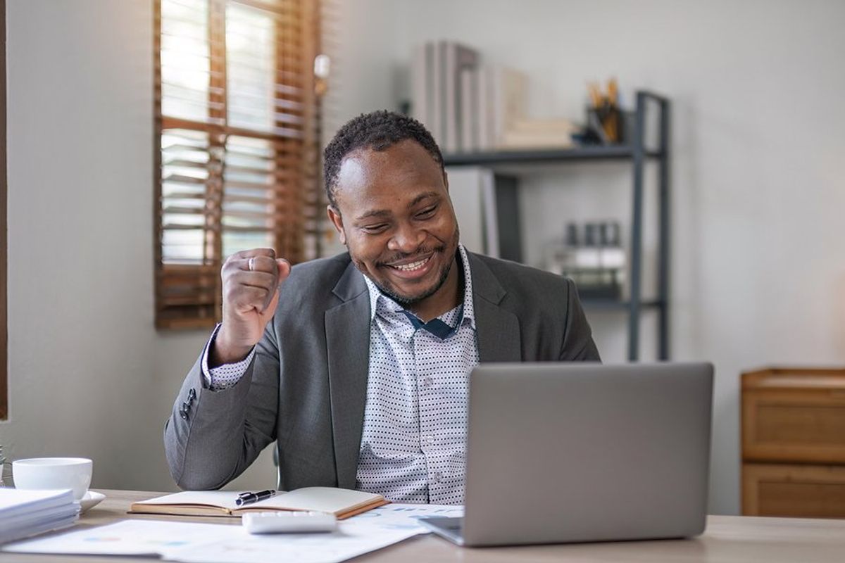 Happy professional man on laptop finds his dream job