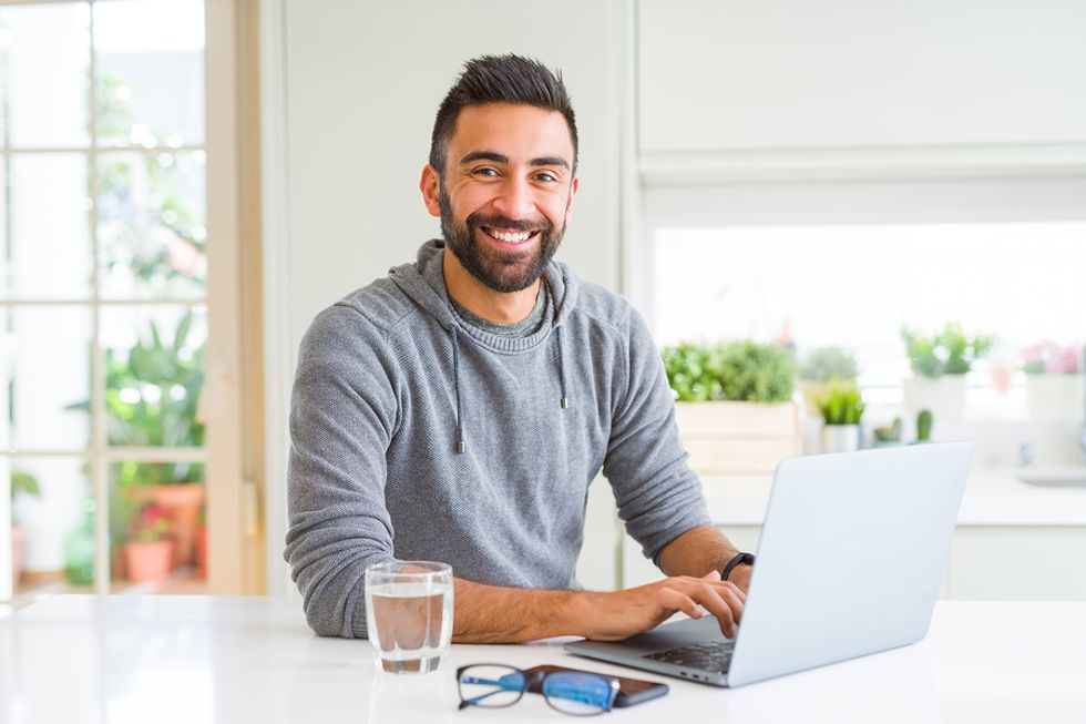 Happy, professional man on laptop starting to use LinkedIn