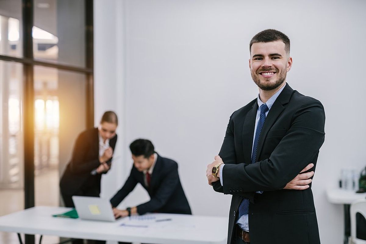 Happy professional man tries to become a better leader at work