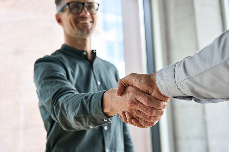 Happy professional shakes hands with the hiring manager knowing he's a good job candidate