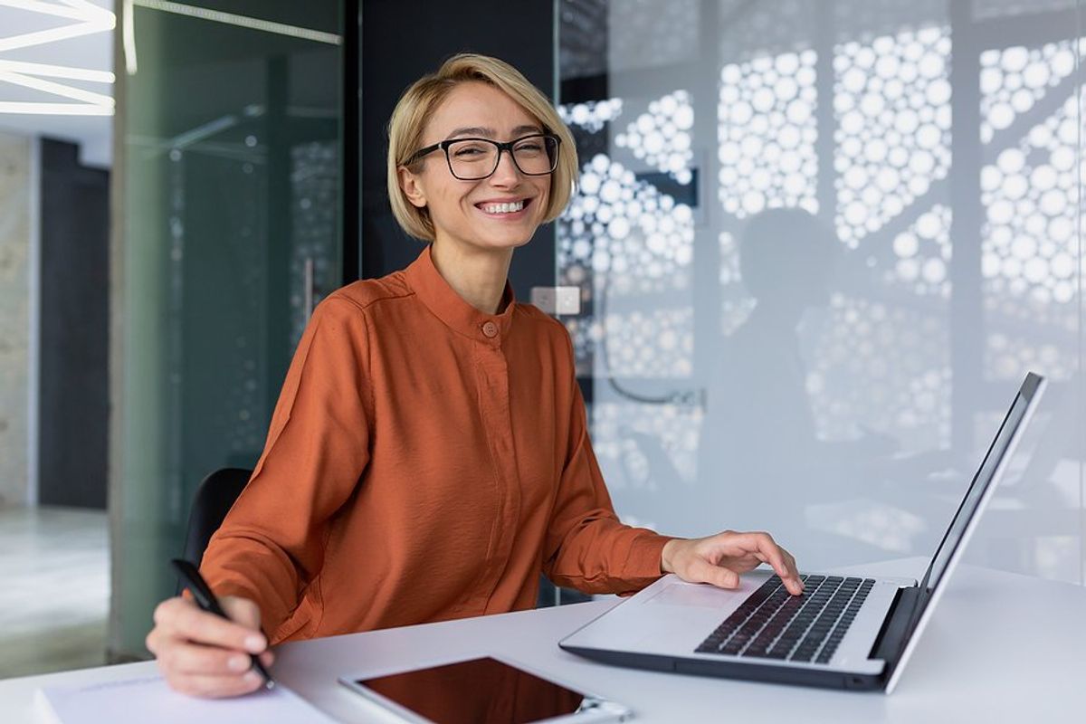 Happy professional woman on laptop achieves career satisfaction