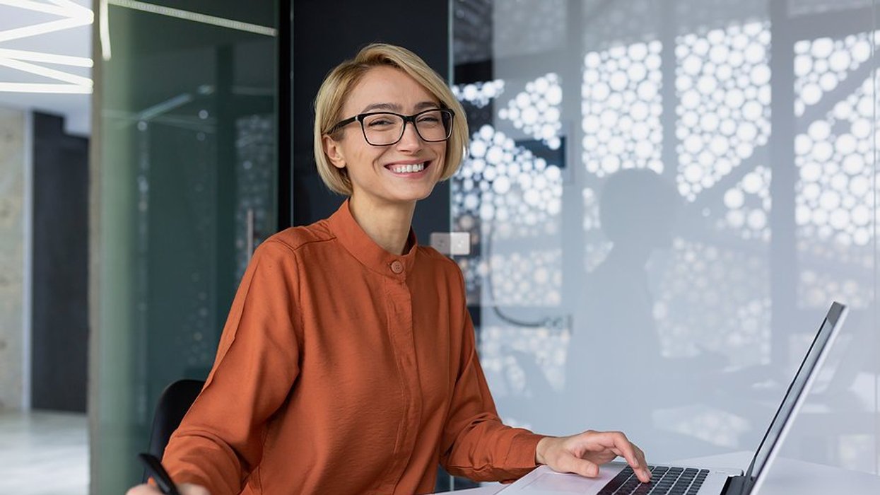 Happy professional woman on laptop achieves career satisfaction
