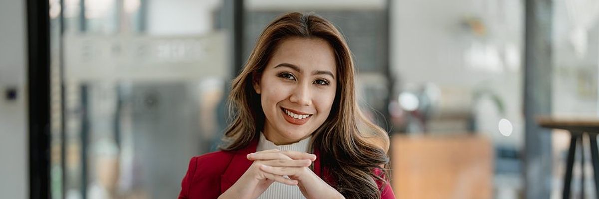 Happy professional woman sits at her desk at work
