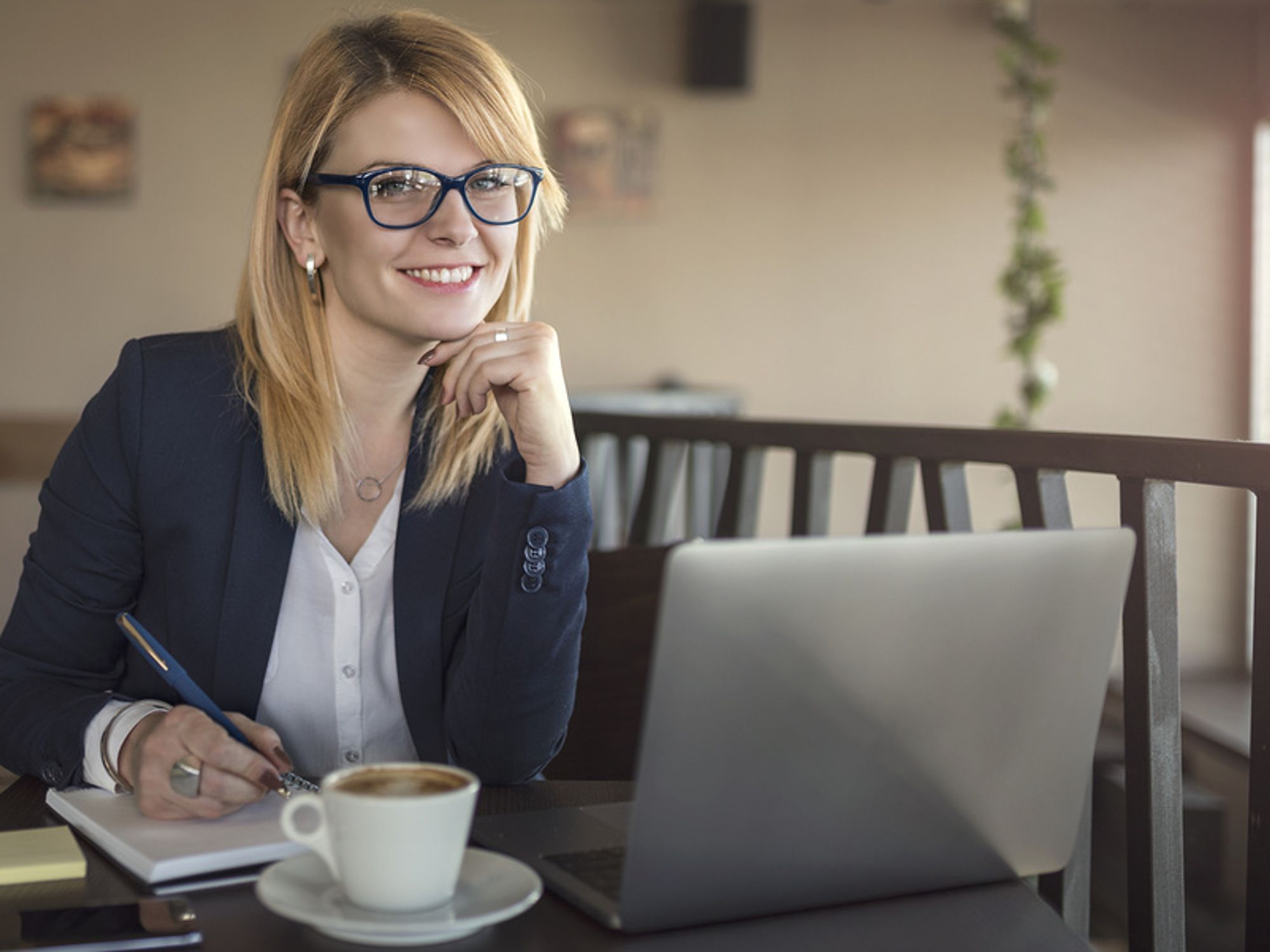 Happy professional woman sitting at her desk and answering questions that help her find her dream job.