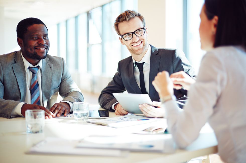 Happy professionals talk during a work meeting