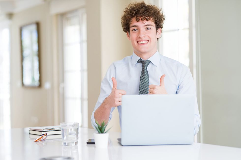 Happy recent college graduate on laptop networks his way into a job