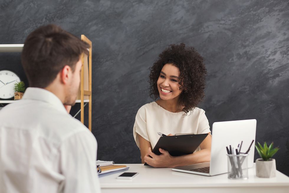 Happy recruiter / hiring manager interviews a job candidate during the summer