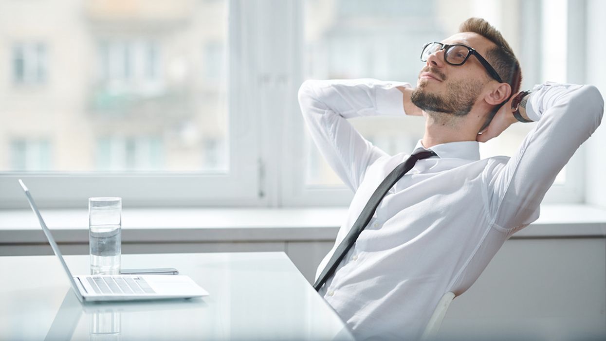 Happy, relaxed, professional man at work achieves work-life balance