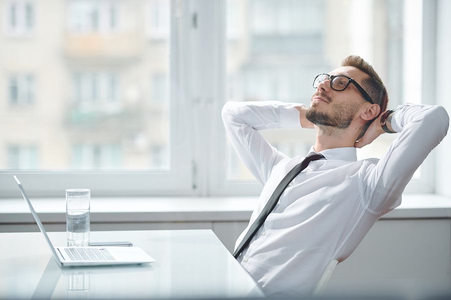 Happy, relaxed, professional man at work achieves work-life balance