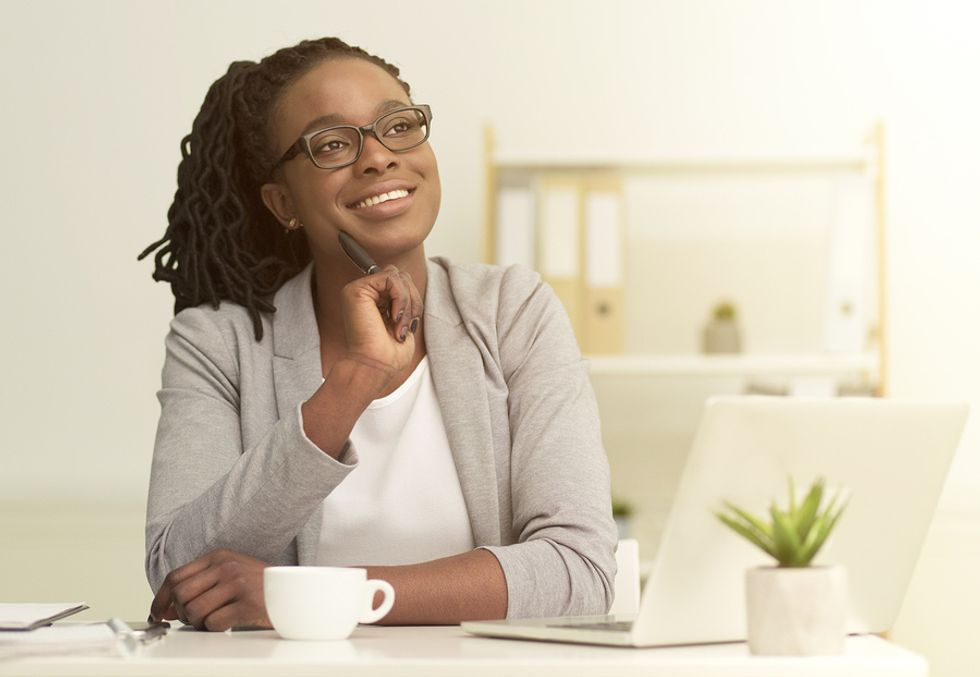 Happy, thinking professional woman has time to pursue hobbies after achieving work-life balance