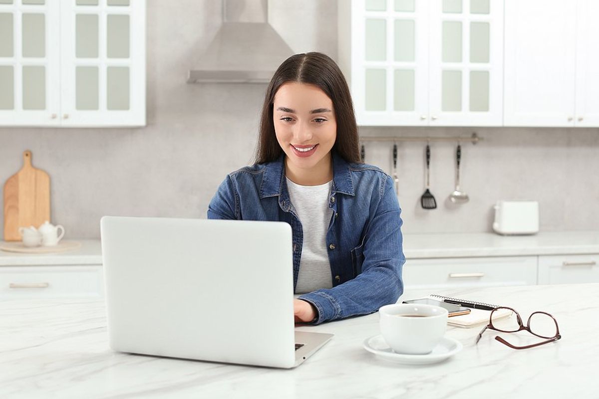 Happy woman laptop follows up on her resume during her job search