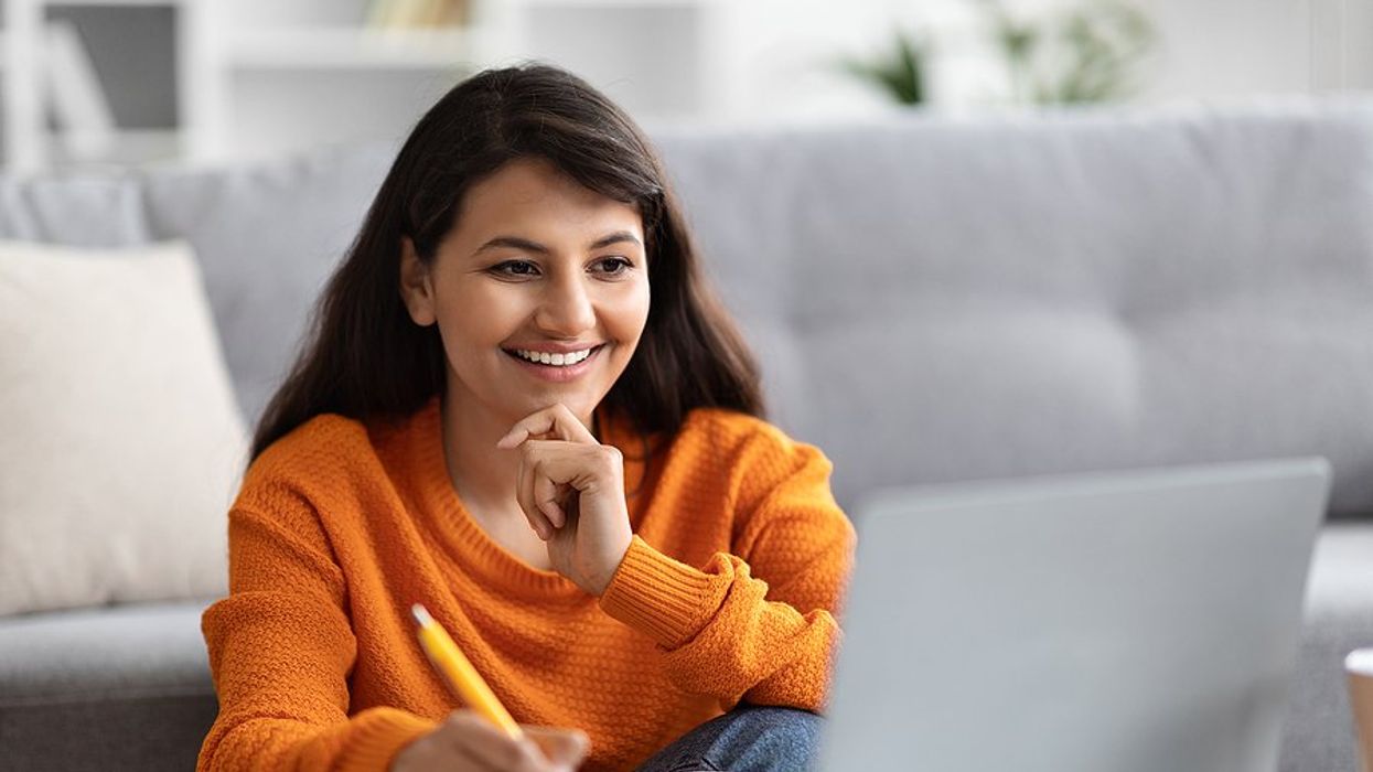 Happy woman on laptop learns how to upskill while not working her dream job