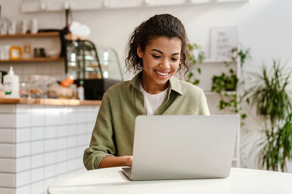 Happy woman on laptop networks on LinkedIn