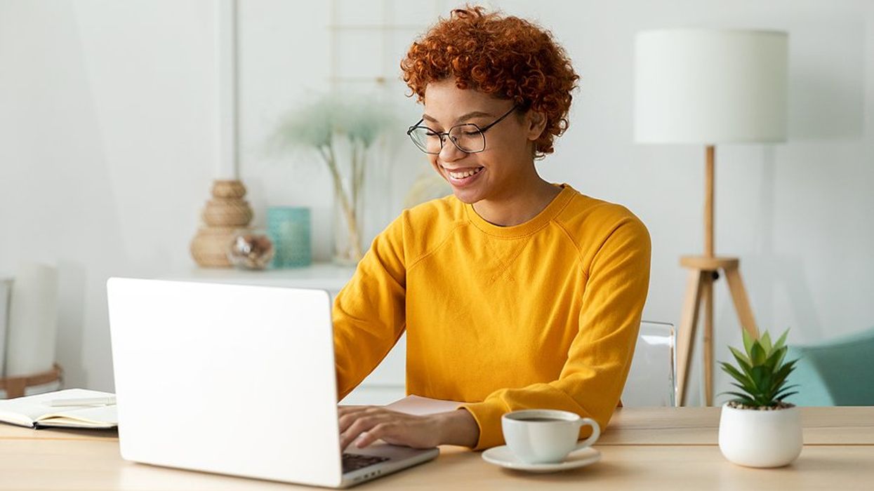 Happy woman on laptop works from home