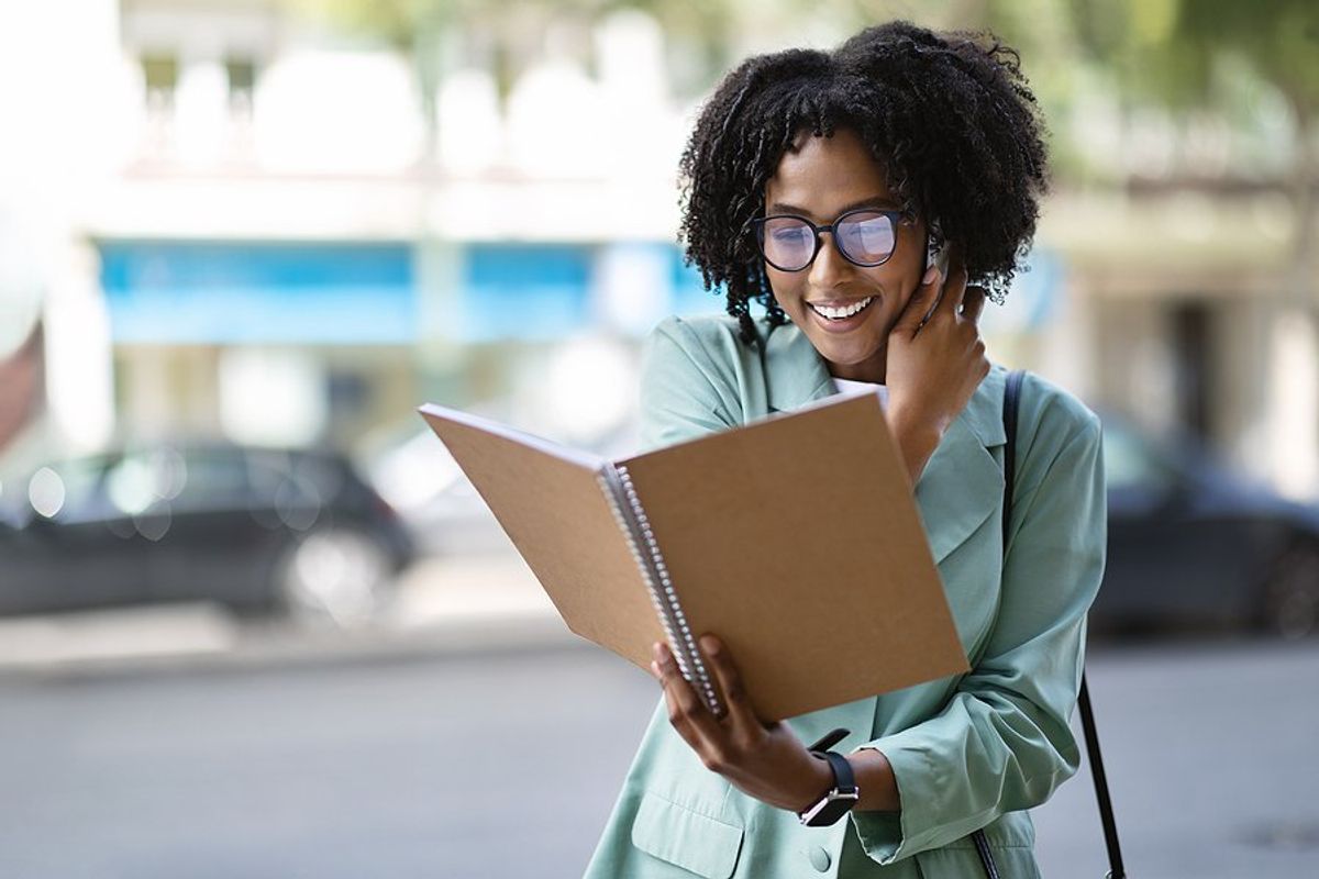 Happy woman on phone looks at her notes and tries to relaunch her career