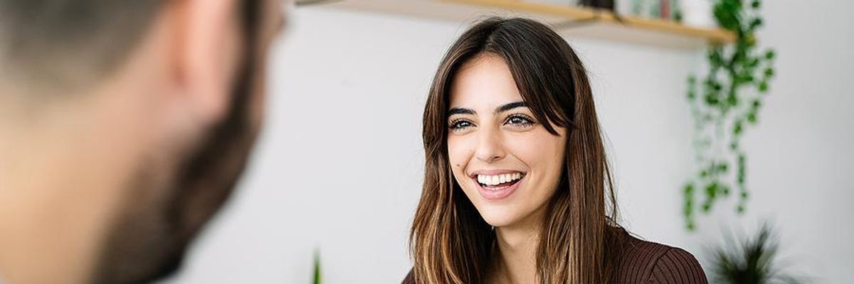 Happy woman smiles while talking to her coworker