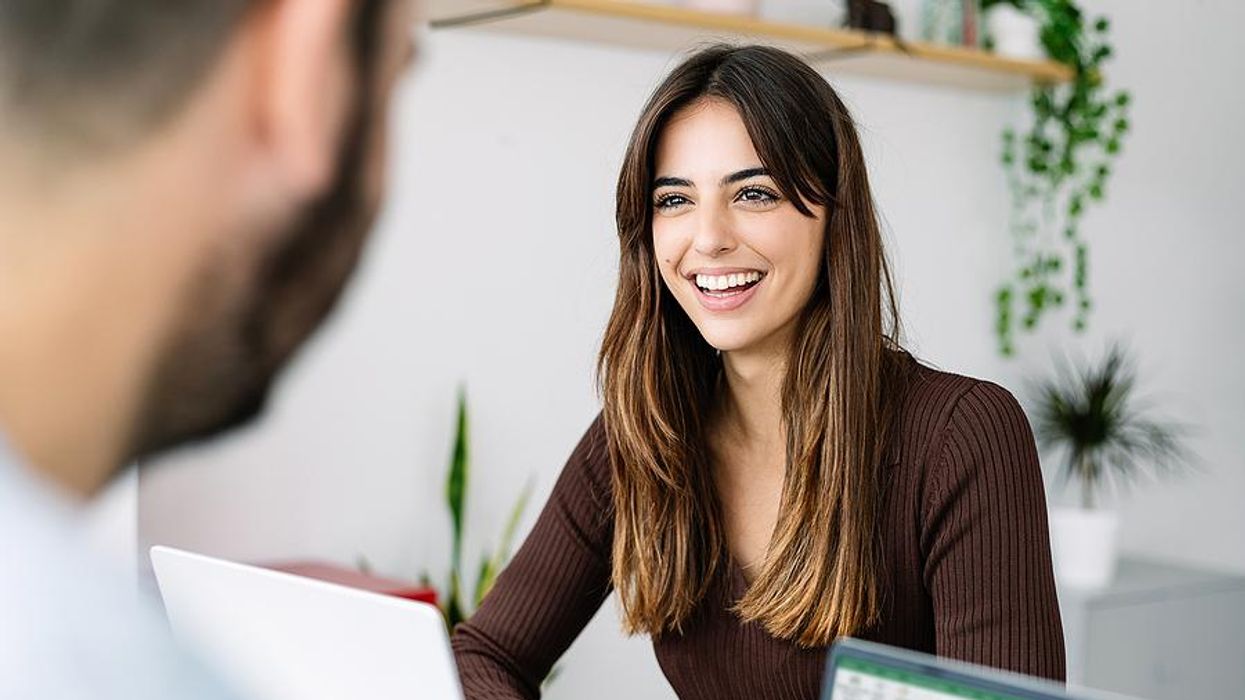 Happy woman smiles while talking to her coworker