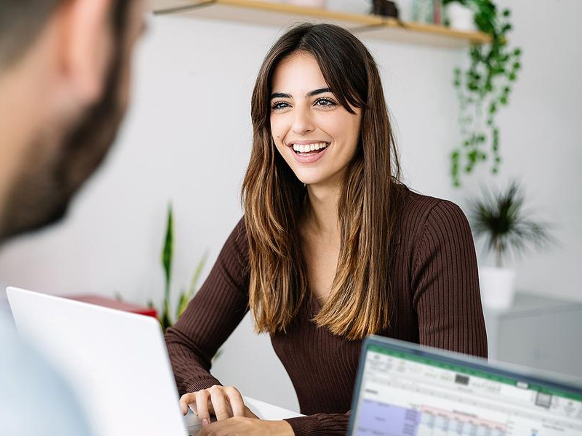Happy woman smiles while talking to her coworker