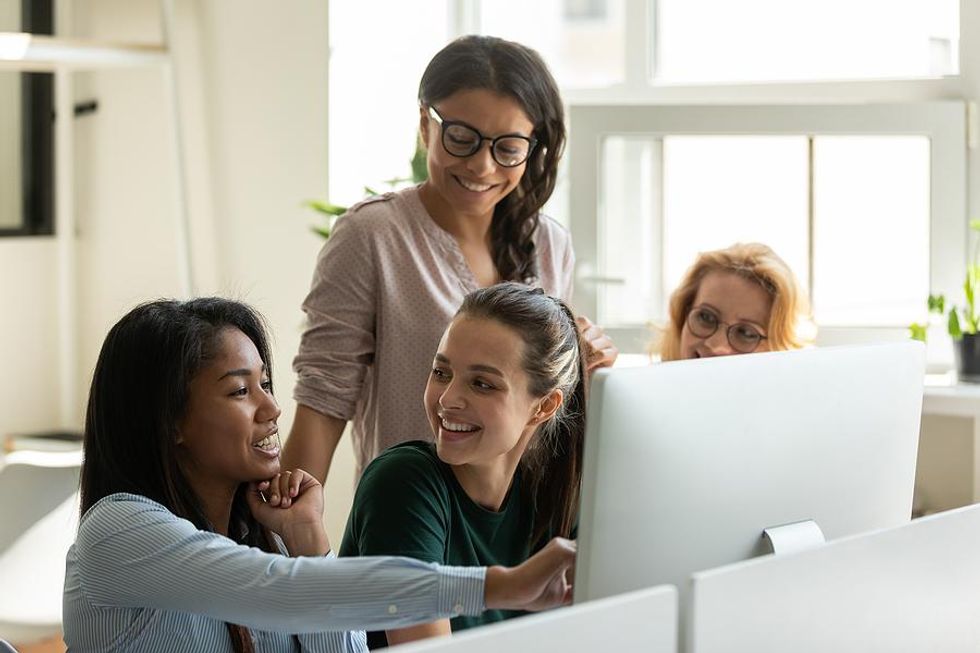 Happy woman talks to her coworkers and tries to make friends at her new job