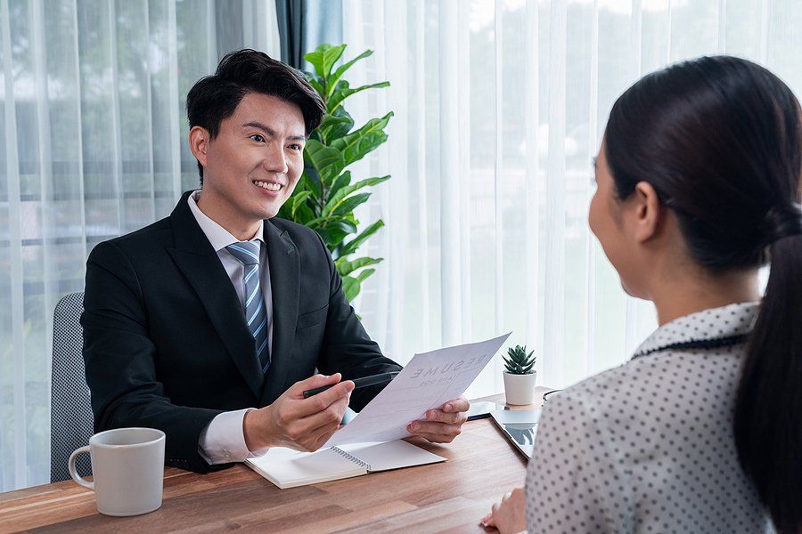 Hiring manager conducting an interview asks a job candidate about a time she went above and beyond