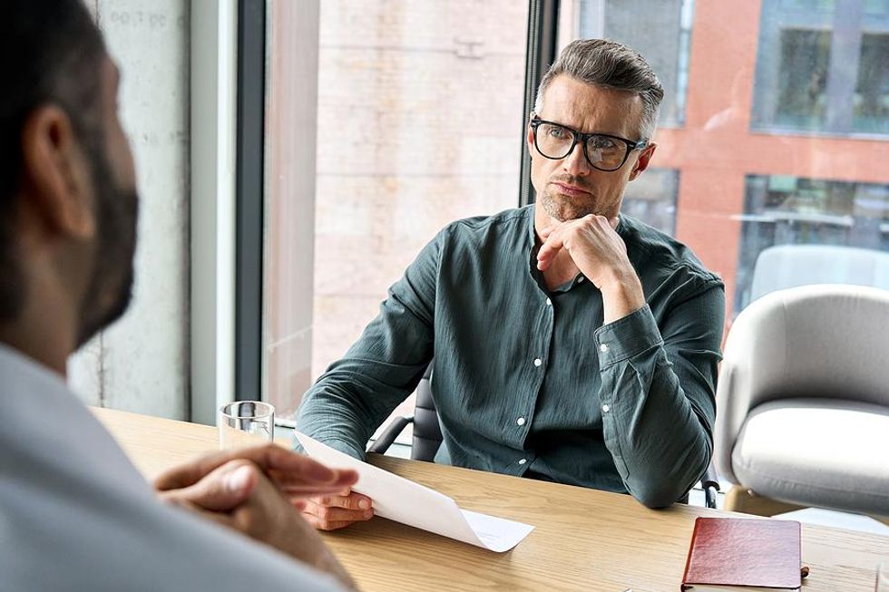 Hiring manager holds a job candidate's resume during an interview