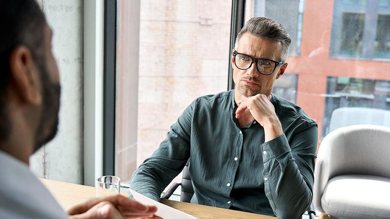 Hiring manager holds a job candidate's resume in an interview