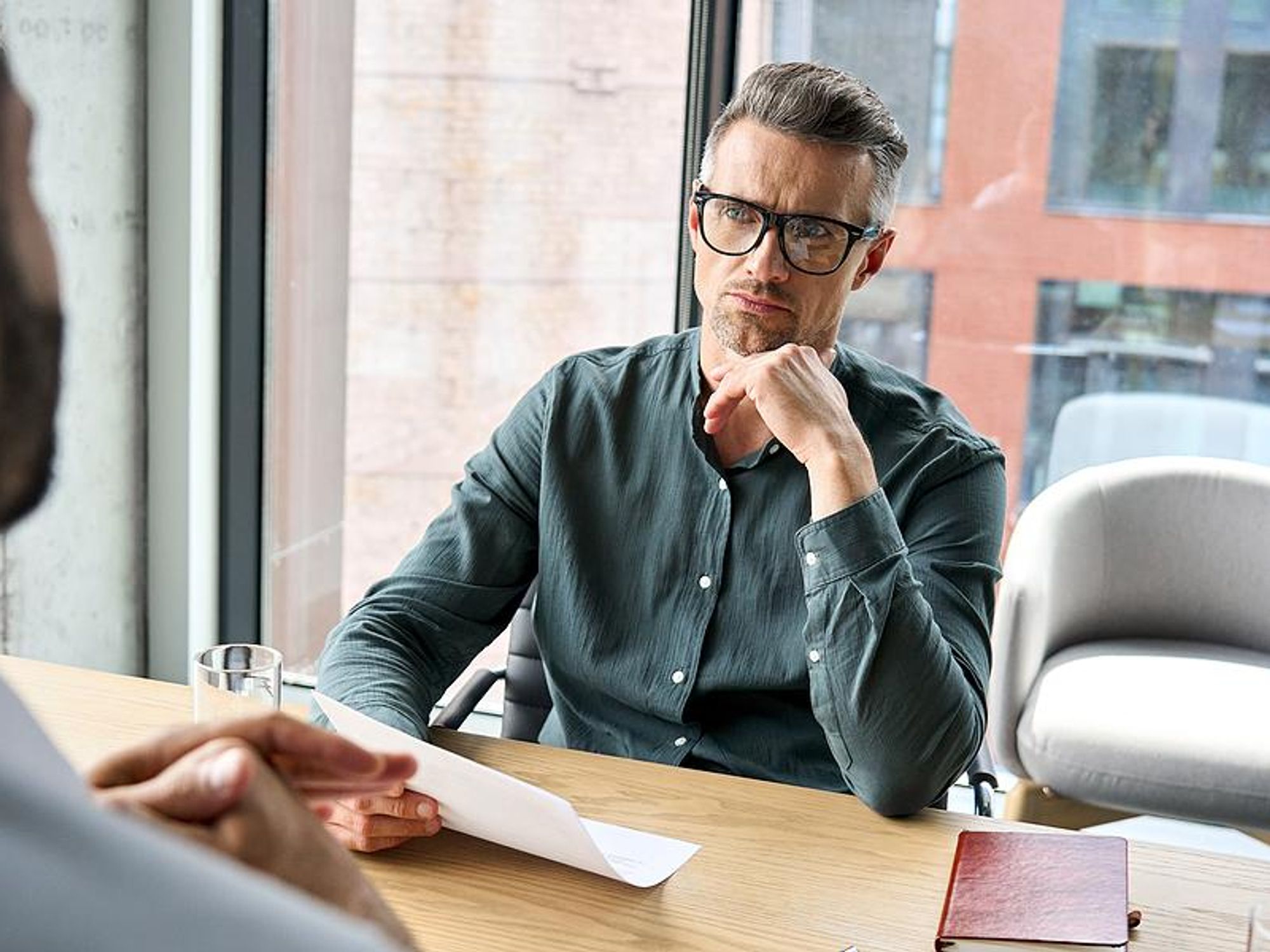 Hiring manager holds a job candidate's resume in an interview