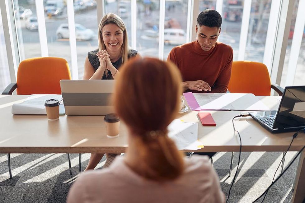 Hiring manager listens as the job candidate asks her a question during the interview