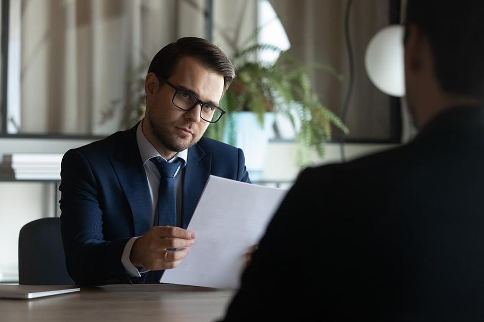 Hiring manager looks at job candidate after he ask a desperate question in a job interview