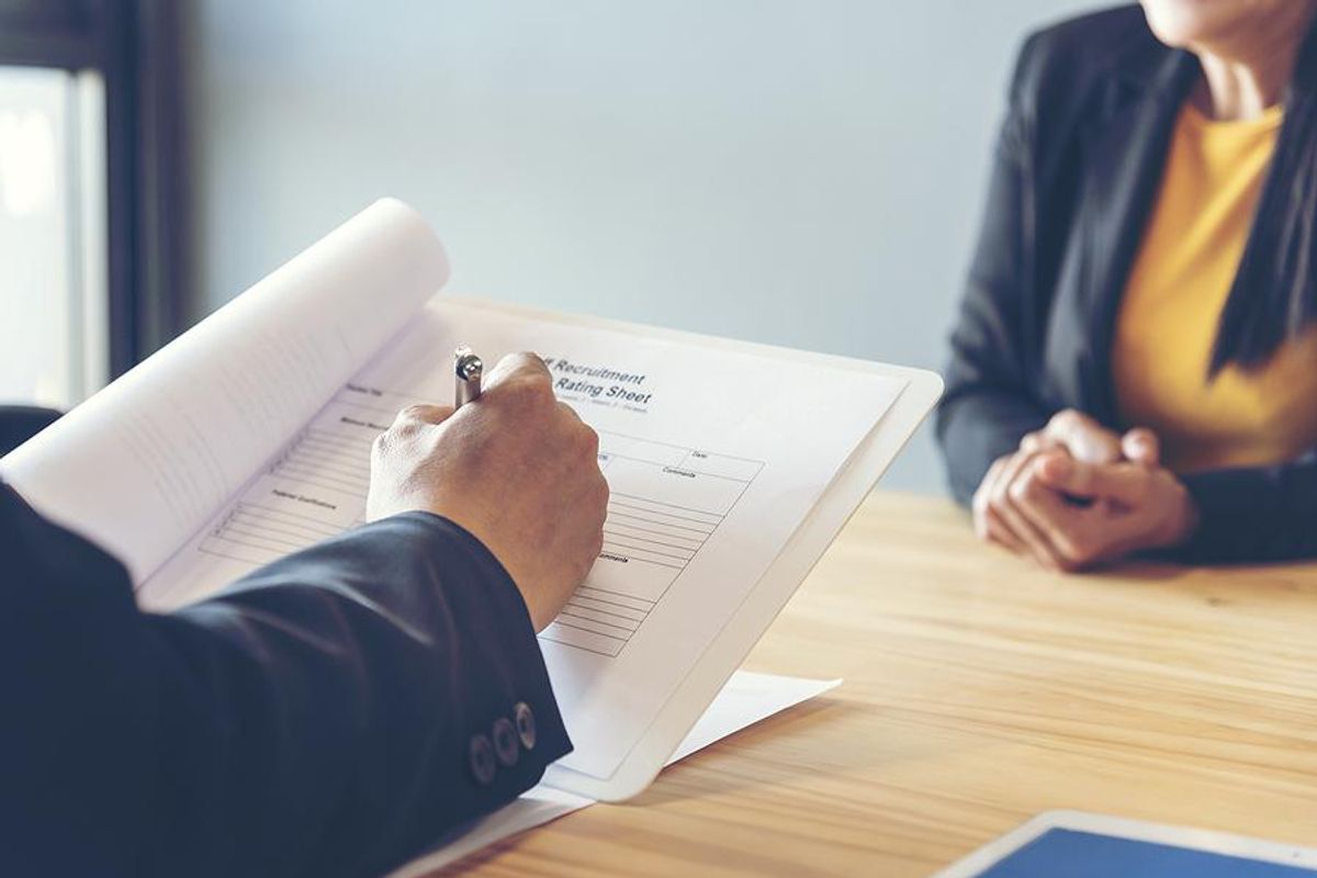 Hiring manager looks at job candidate's resume during an interview