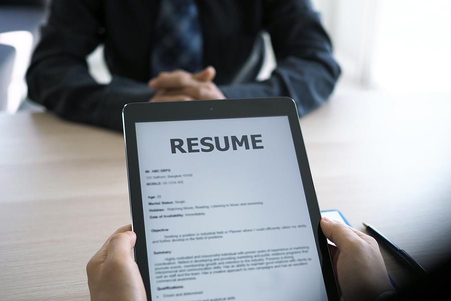 Hiring manager looks at the job applicant's resume during an interview