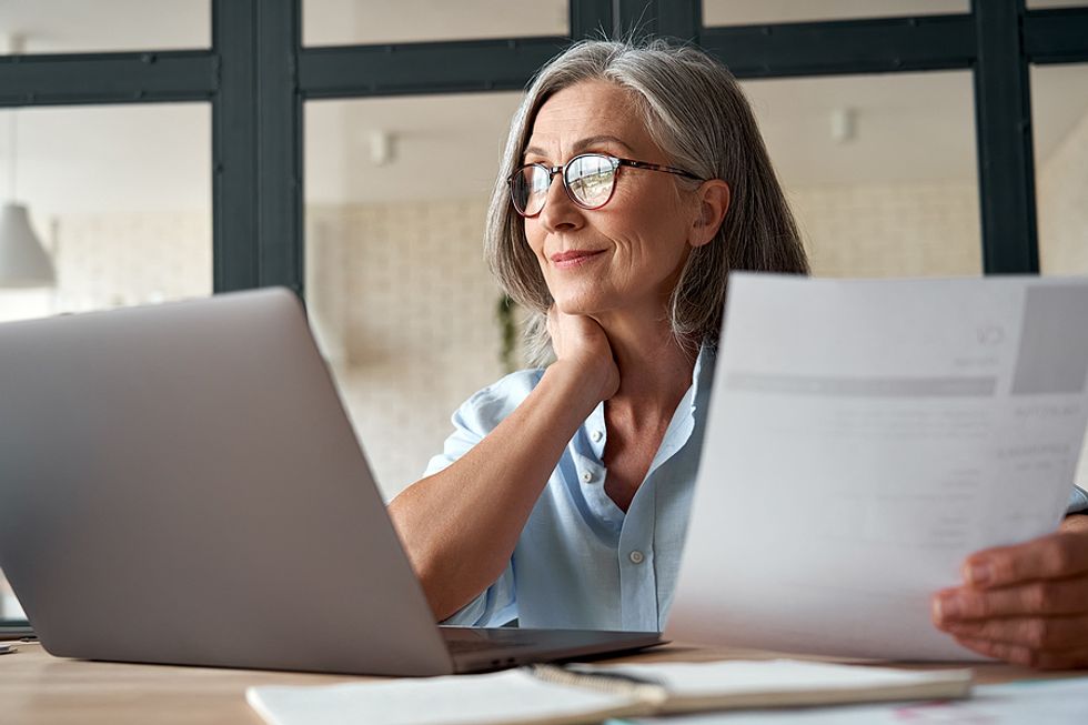 Hiring manager on laptop reads an executive resume