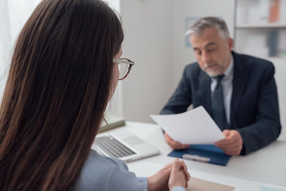 Hiring manager reads a job candidate's references in an interview