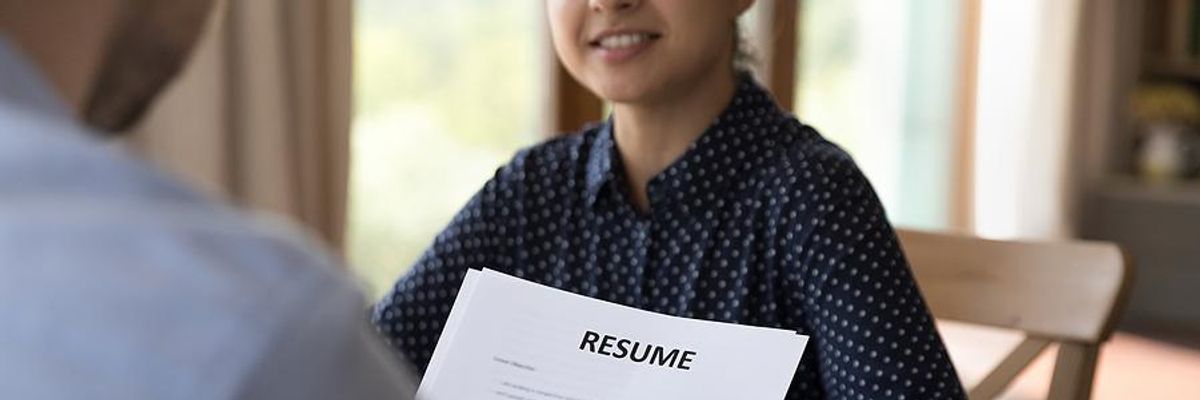 Hiring manager reads a job candidate's resume during an interview
