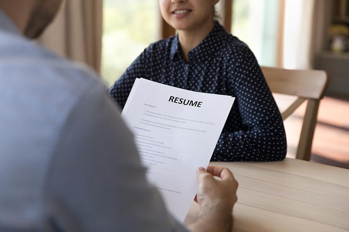 Hiring manager reads a job candidate's resume during an interview