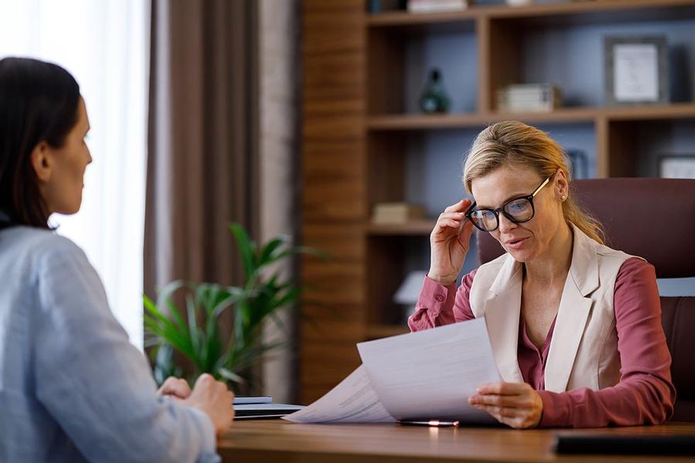 Hiring manager reads a job candidate's resume during an interview