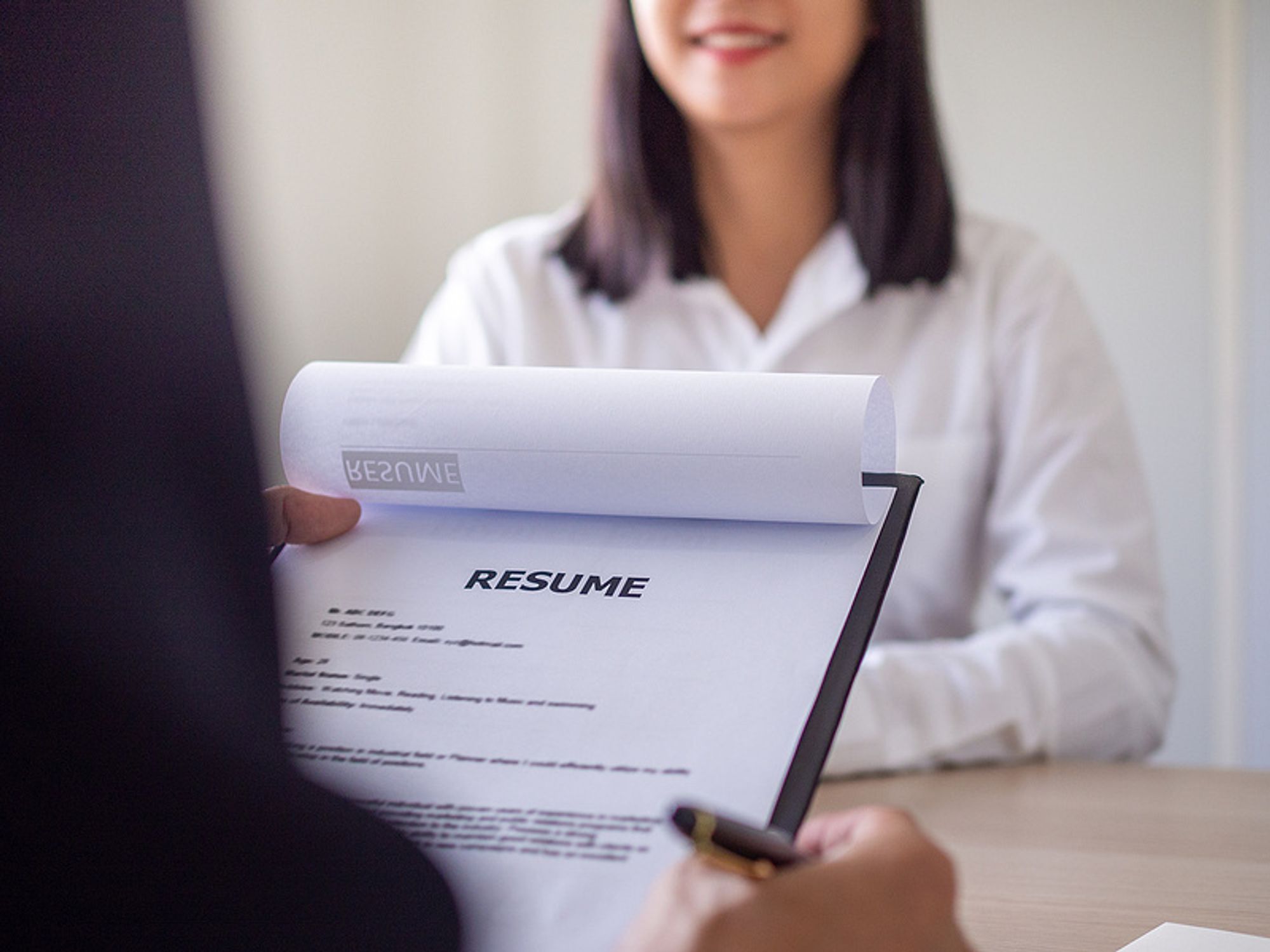 Hiring manager reads the job applicant's resume during an interview