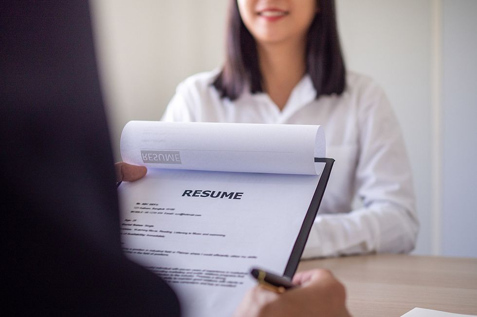 Hiring manager reads the job applicant's resume during an interview