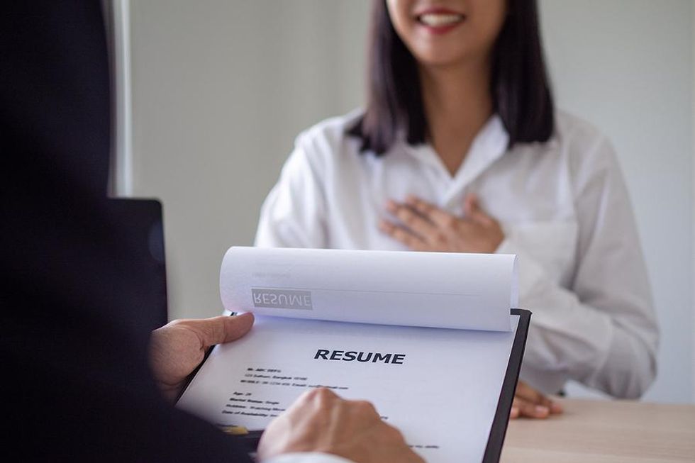 A hiring manager reviews a job applicant's resume during the interview