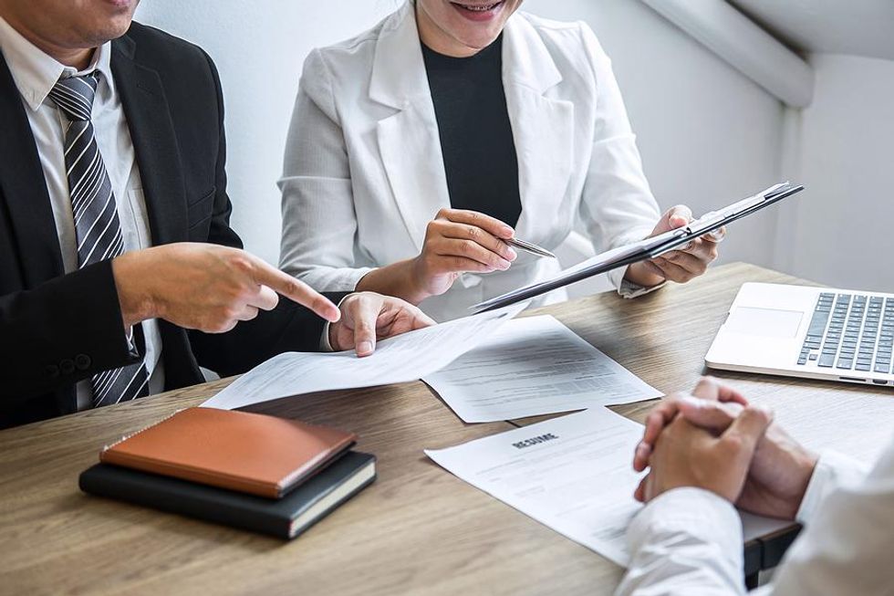 Hiring managers discuss a job candidate's resume during an interview