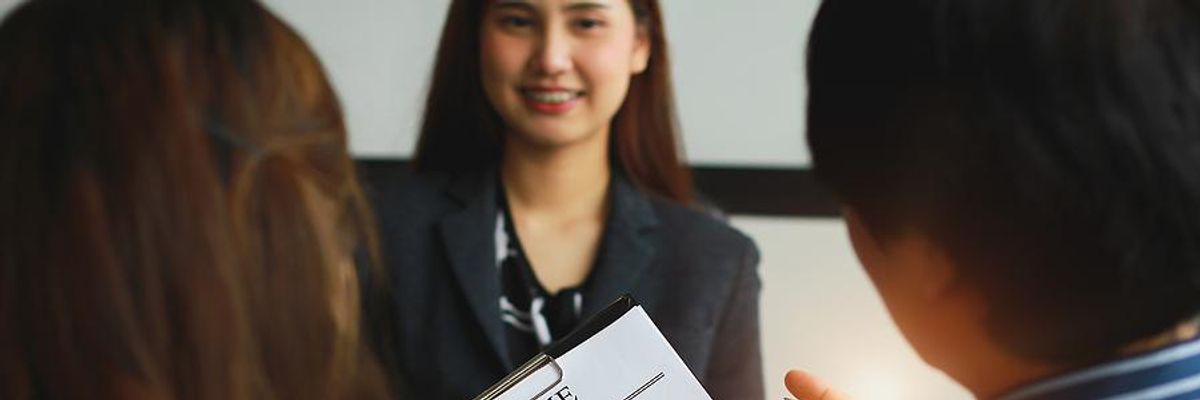 Hiring managers look at a job candidate's resume during an interview